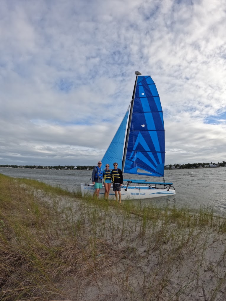 Group of three guests with the Hobie Cat on an Emerald Isle shoreline