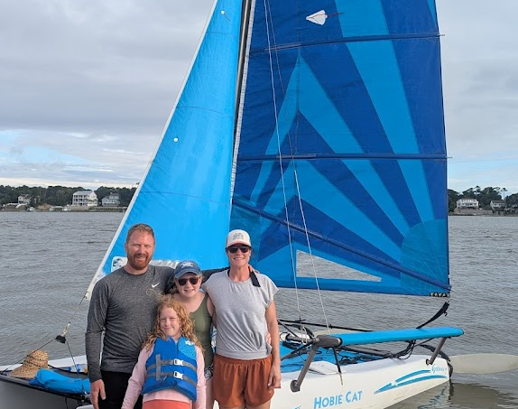 Family posing beside the Hobie Cat after a sailing cruise